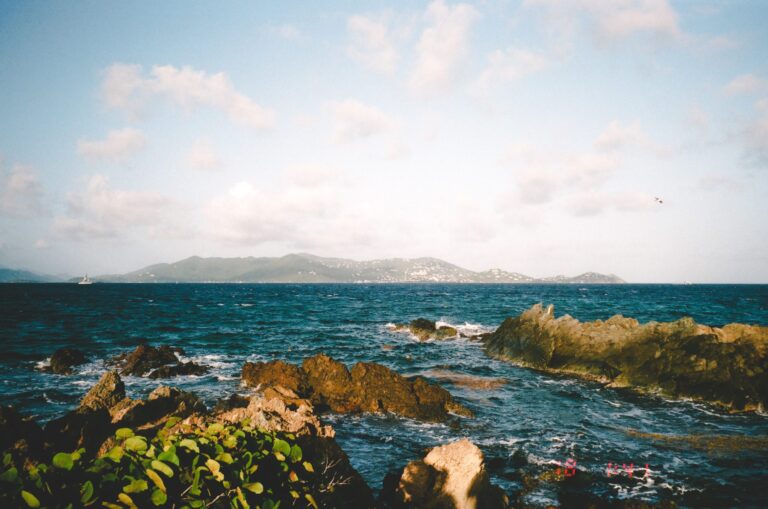 a wide shot from the beach of a tropical island, looking across the water to another local island.